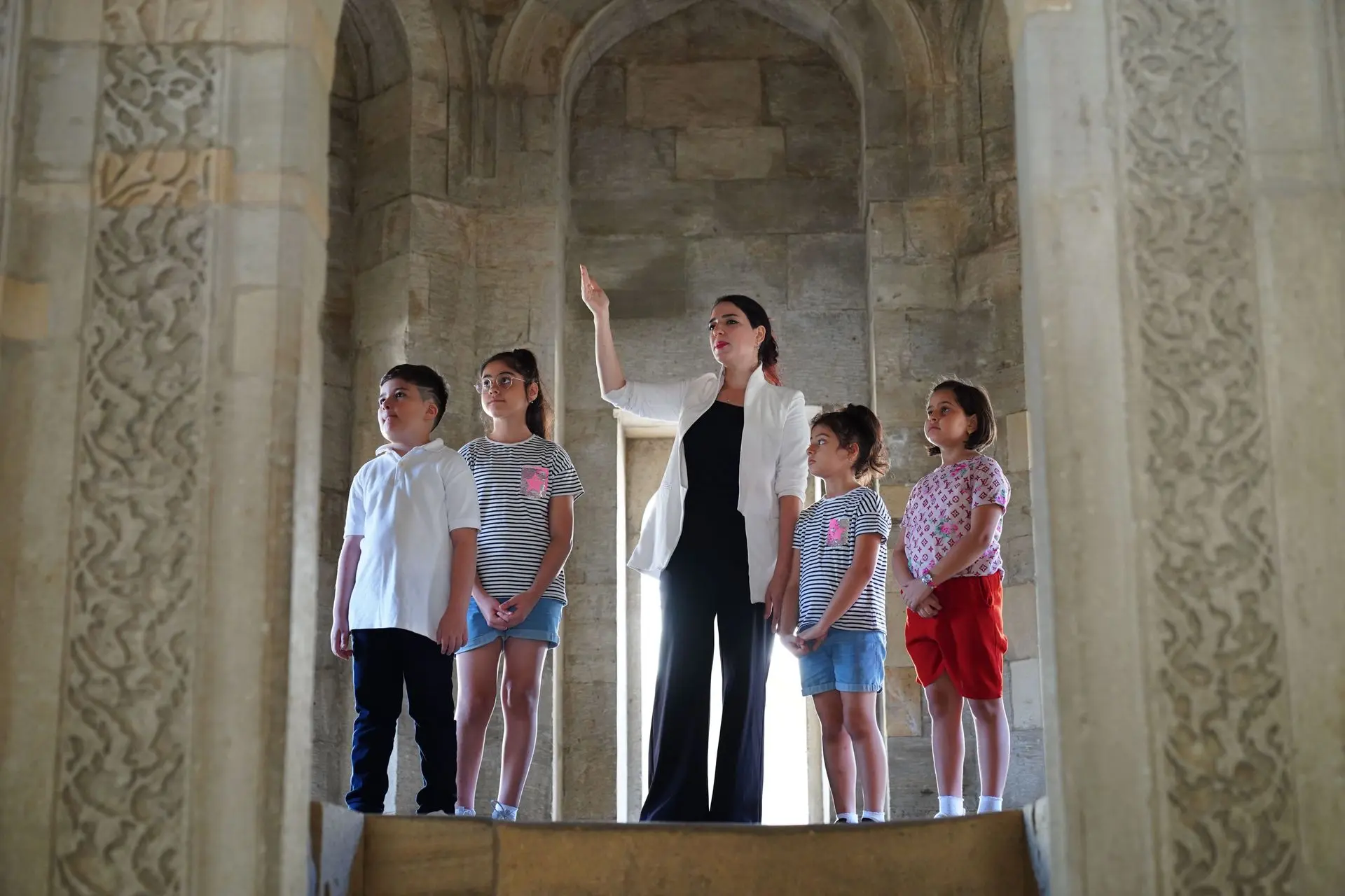A tour guide leading a small group through a historic stone gateway in Istanbul A tour guide leading a small group through a historic stone gateway in Istanbul