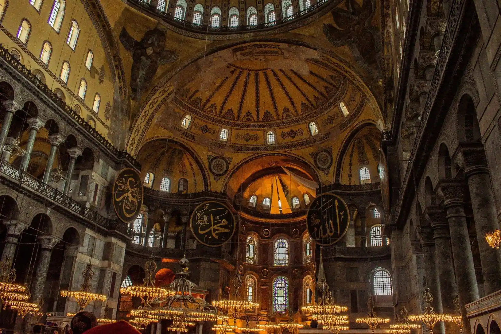 The interior of Hagia Sophia with its dome, chandeliers and calligraphy roundels The interior of Hagia Sophia with its dome, chandeliers and calligraphy roundels