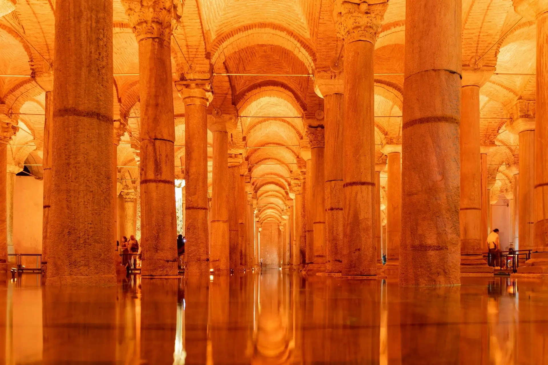 Visitors among the illuminated columns of the Basilica Cistern Visitors among the illuminated columns of the Basilica Cistern